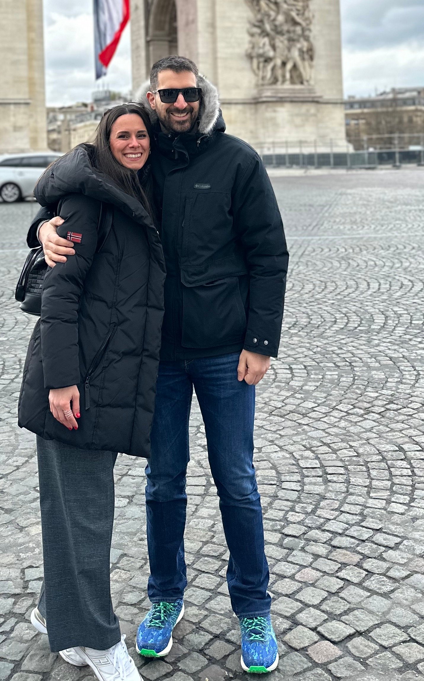 Konstantina and Alex hugging in front of the Arc de Triomphe in Paris