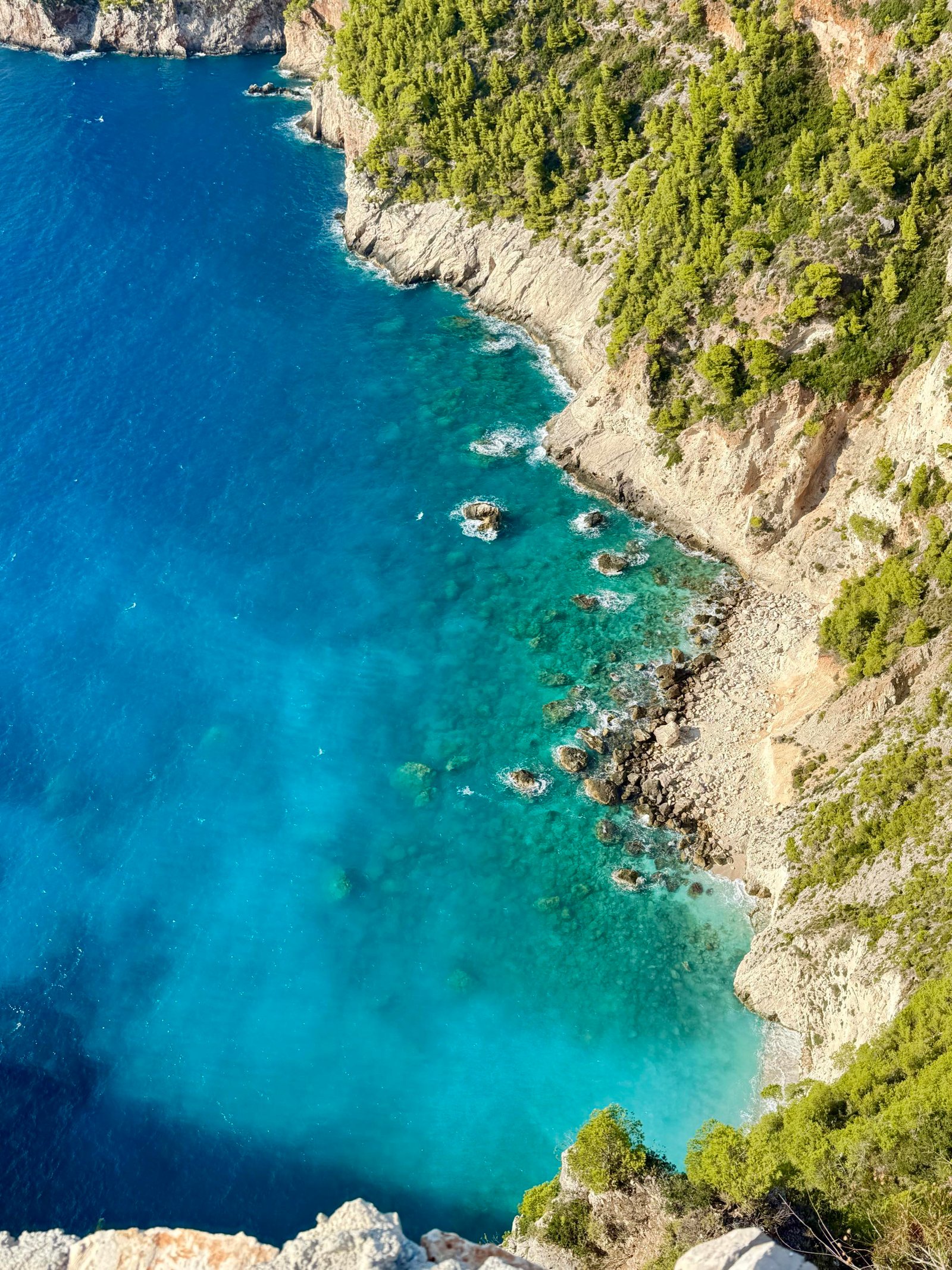 Aerial view of a turquoise coastline and rocky cliffs