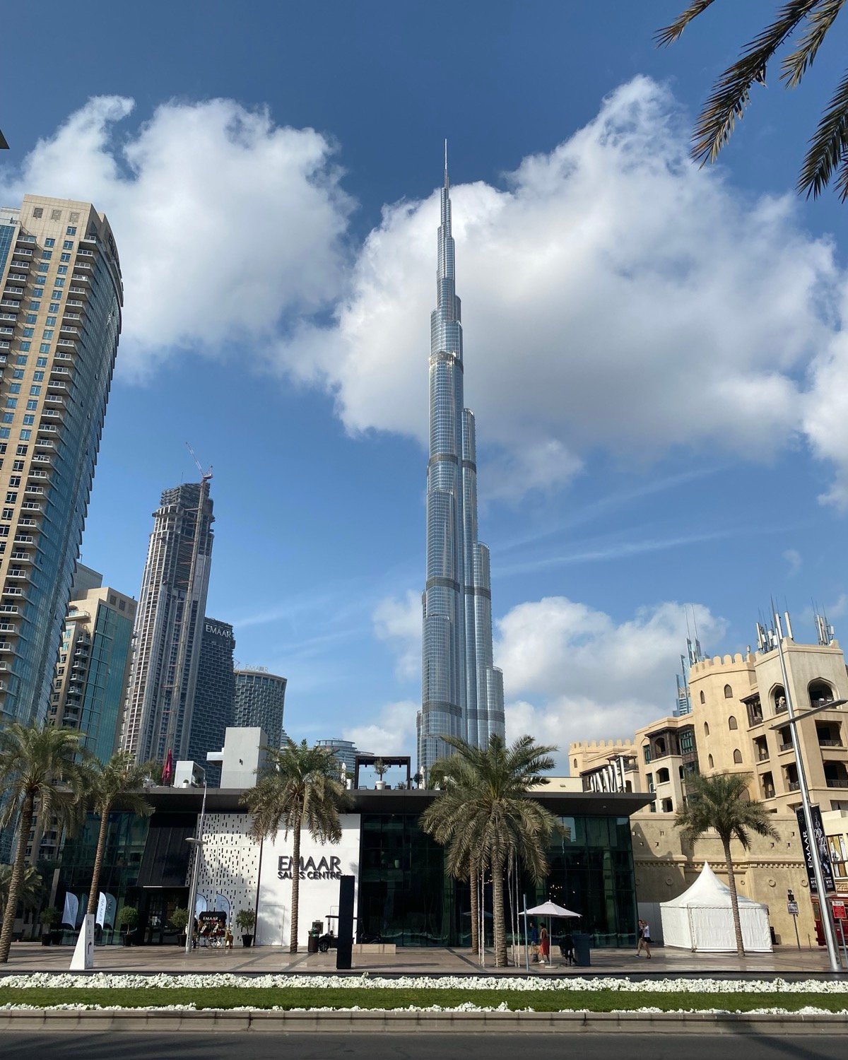 The Burj Khalifa rising above palm trees and downtown Dubai under a blue sky
