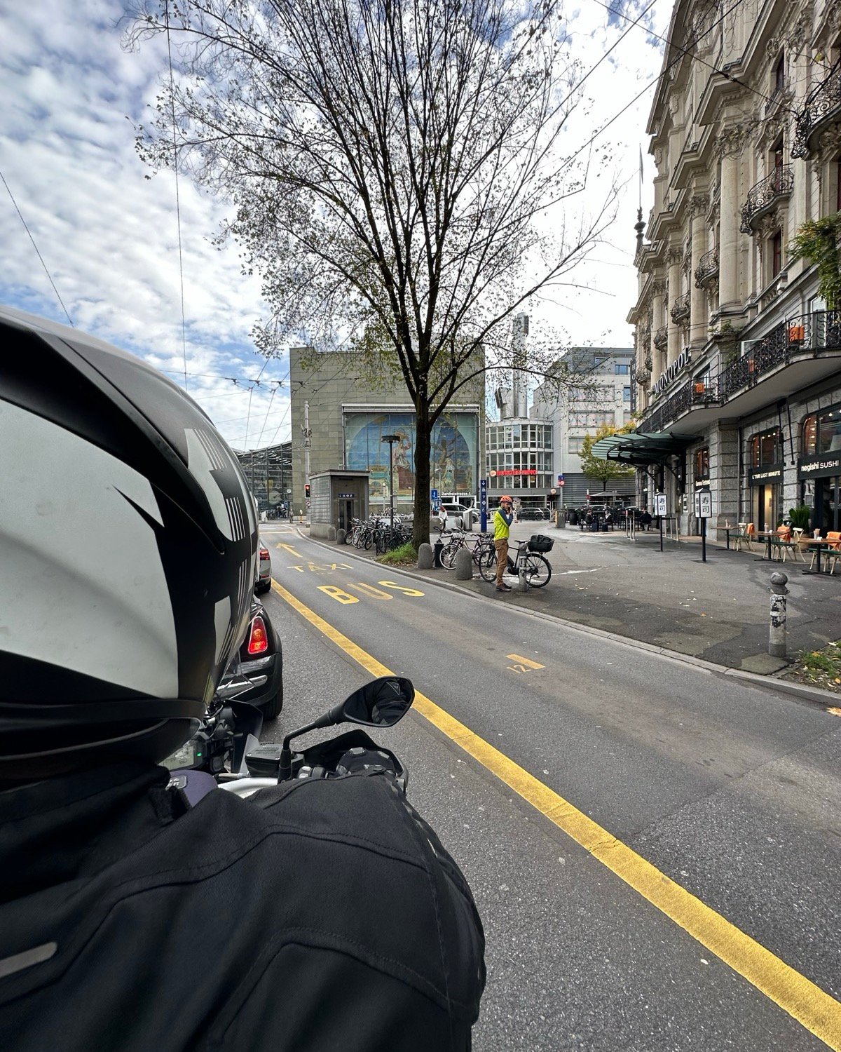 View over a motorcycle rider’s shoulder down a city street in Lucerne